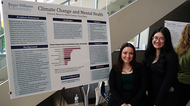 Two students standing next to their poster that reads "Climate Change and Mental Health"
