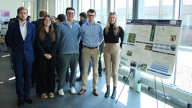 Five students stand next to their poster about the Shad Dam removal plan