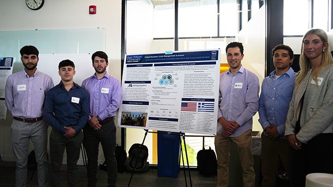 Six MBA students standing next to their poster at SASH