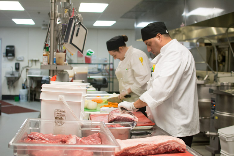 Chefs cutting meat