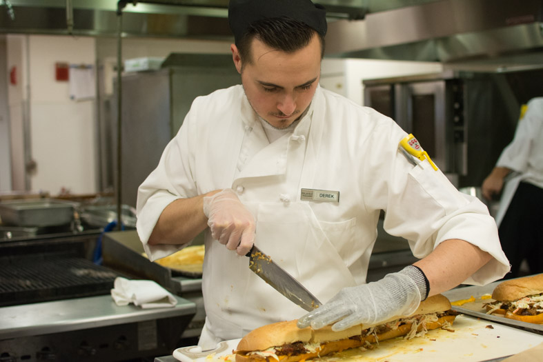 RWU chef cutting pork sandwich