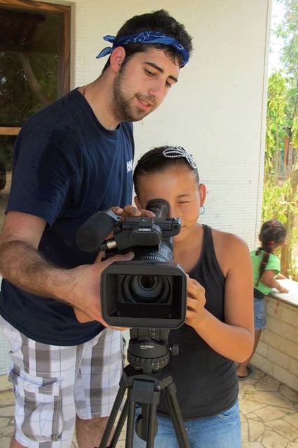 Student helping a child with a video camera