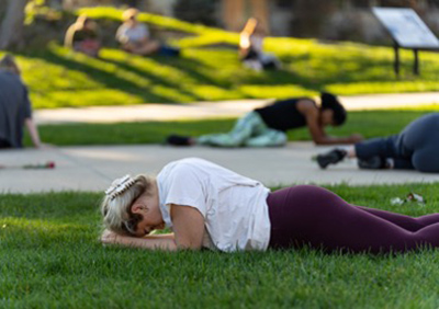 Student lays on ground as part of STAND performance