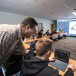 Professor assists student with computer