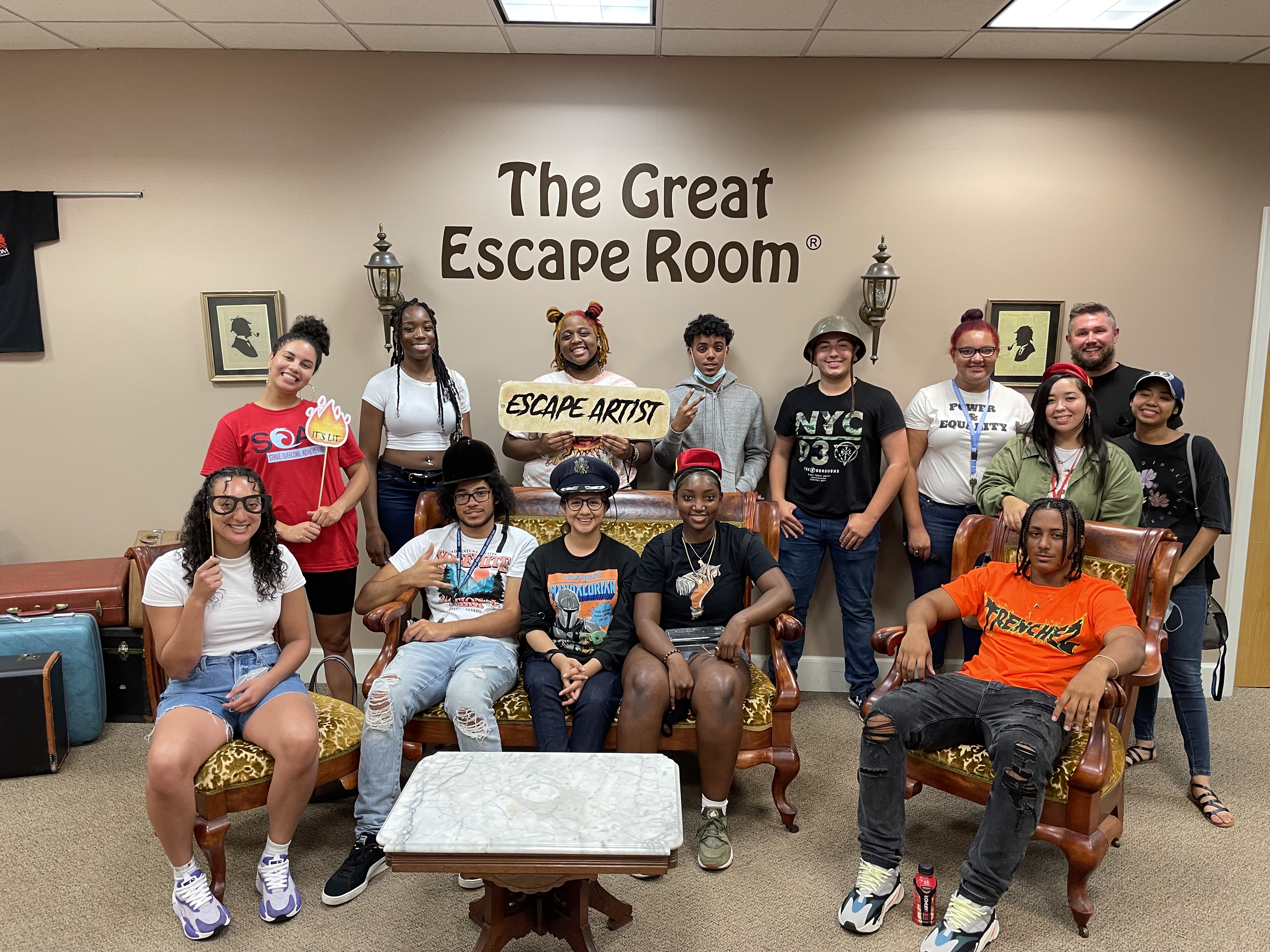 students taking a group picture at the lobby of the an escape room