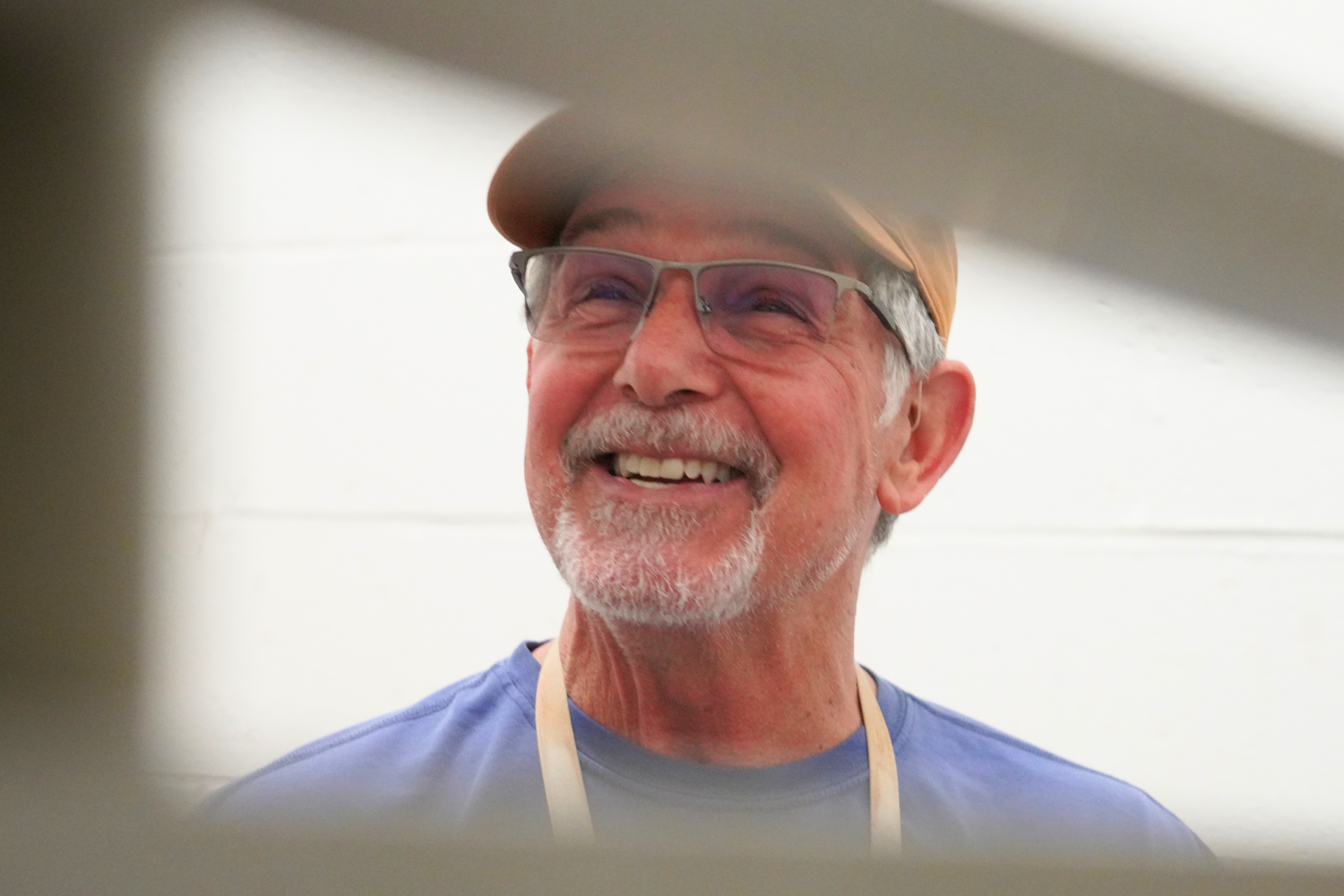 Leonti smiles as he reflects on the experience, framed by wheeled trays holding student and studio works ready for the kiln.