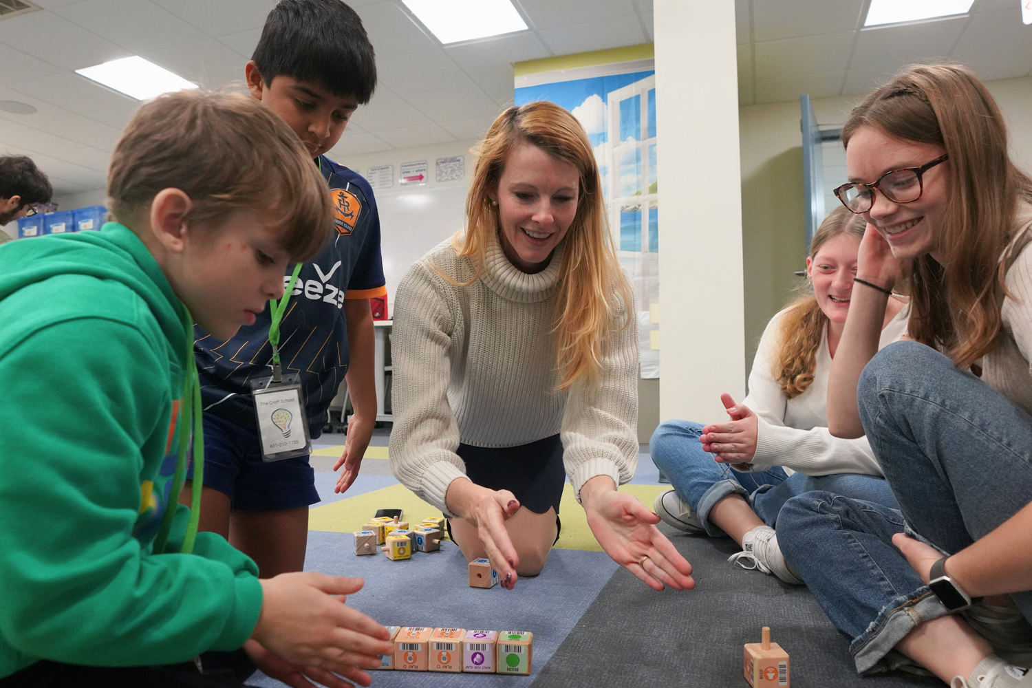 Katherine Blagden, Visiting Assistant Professor of STEM Education, claps to activate a robot.
