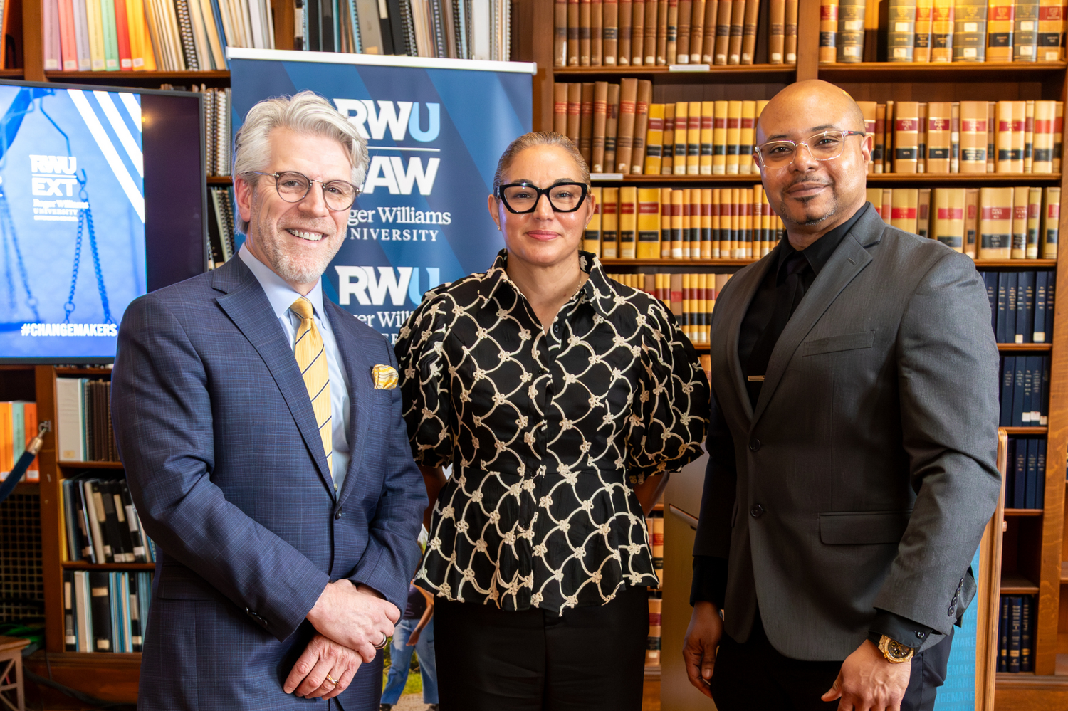 Deans Gregory Bowman, Gena Bianco, and Vaughn J. Crichlow stand together in the Rhode Island State Library.