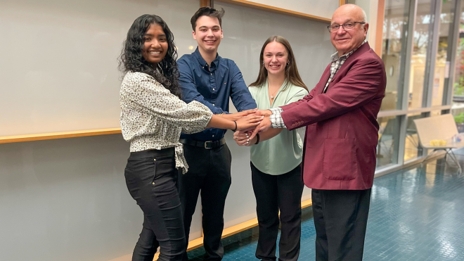 Three RWU interns with Charles Boos, the principal founder of the firm Kaestle Boos Associates.