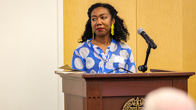 Elon Cook Lee at a podium