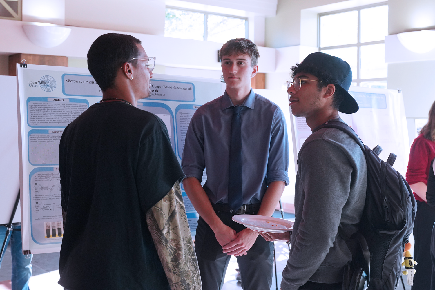 Senior Preston Sharrock speaks with fellow peers at the Summer Research Showcase.