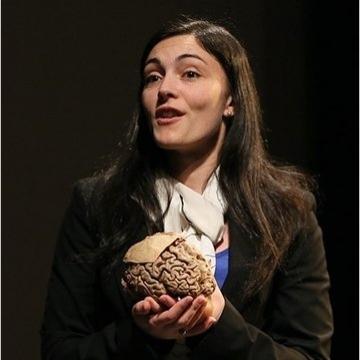 Professor Victoria Heimer-McGinn speaking and holding a human brain.