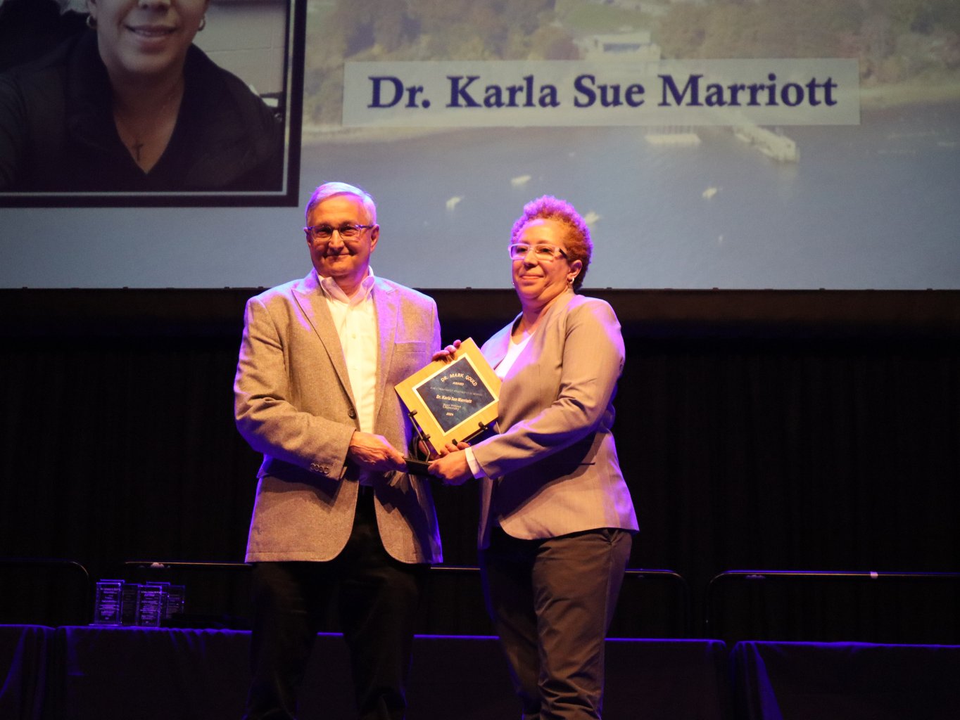 Professor Karla-Sue Marriott receives the Dr. Mark Gould Commitment to Student Learning Award from Interim Dean and Director of the School of Justice Studies David Lambert.