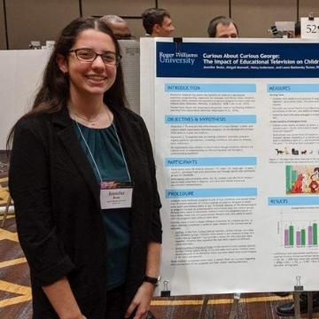 Student Jenn Reale next to a poster explaining her research