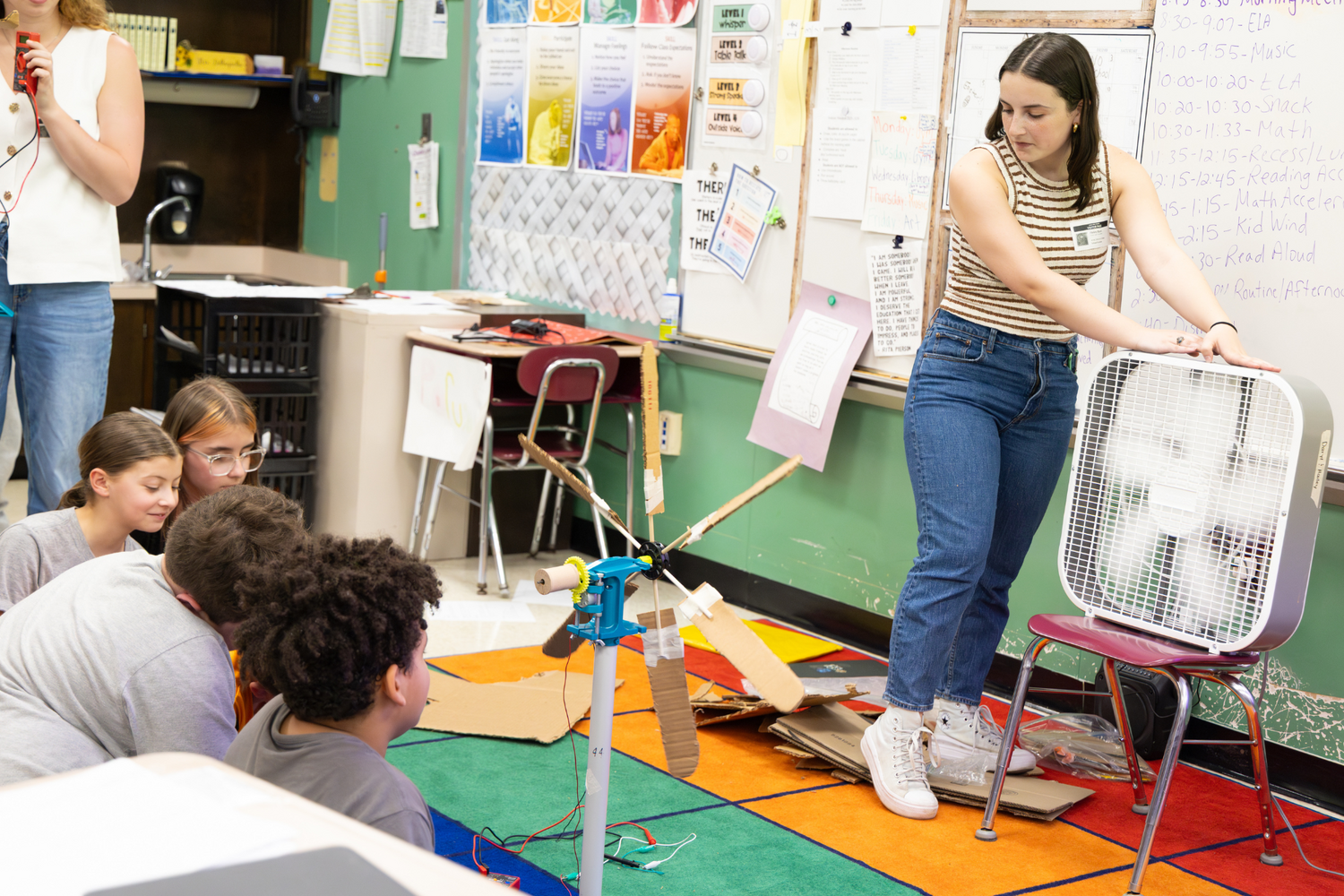 Junior Hailey Black operates the fan as fourth graders prepare to test their wind turbine.