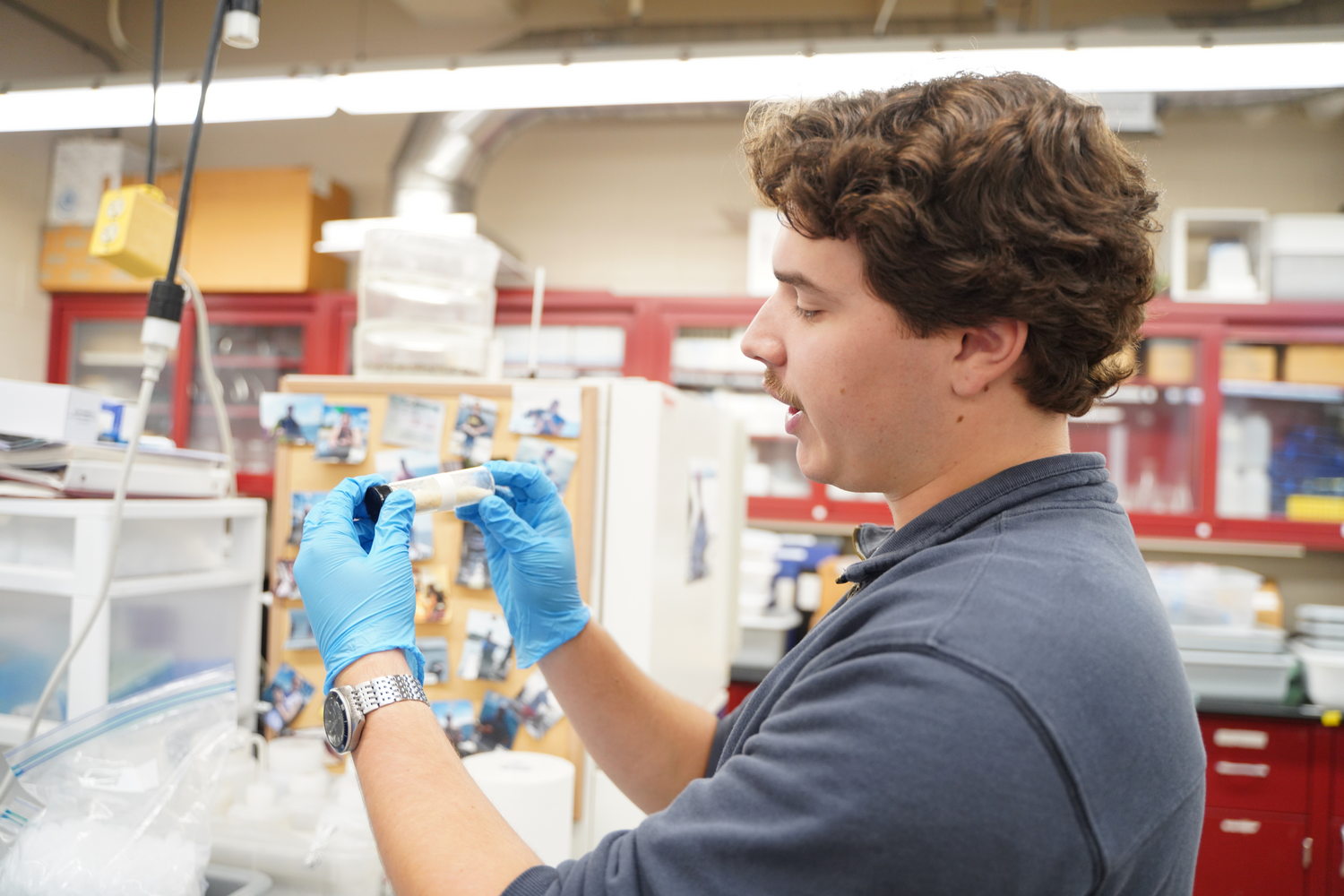 Junior Michael Natoli holds a homogenized fish tissue sample while explaining how specimens from Upper Melville Pond were prepared for mercury analysis.
