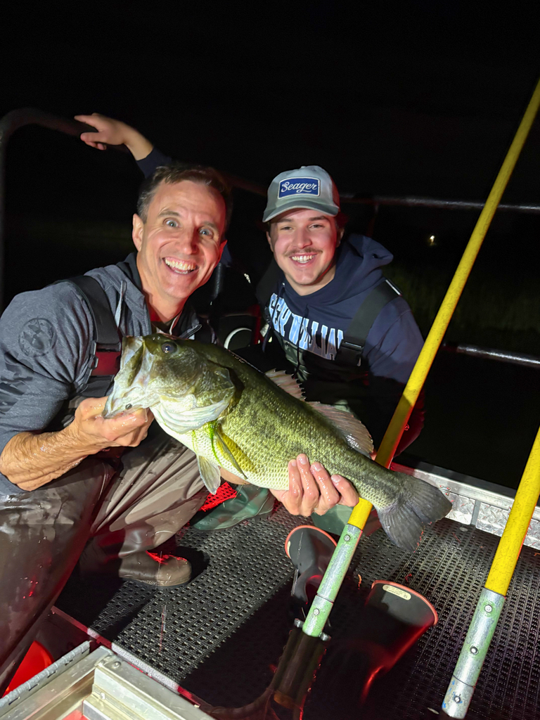 Michael Natoli and Professor of&nbsp;Biology David Taylor show off a catch aboard a boat on Upper Melville Pond.