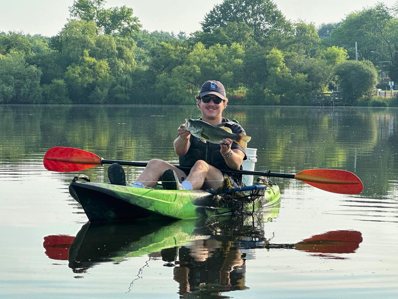 Junior Michael Natoli holds a fish he caught while in a kayak on Upper Melville Pond in Portsmouth, Rhode Island.