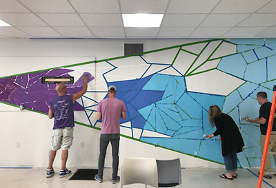 Staff putting in a mural