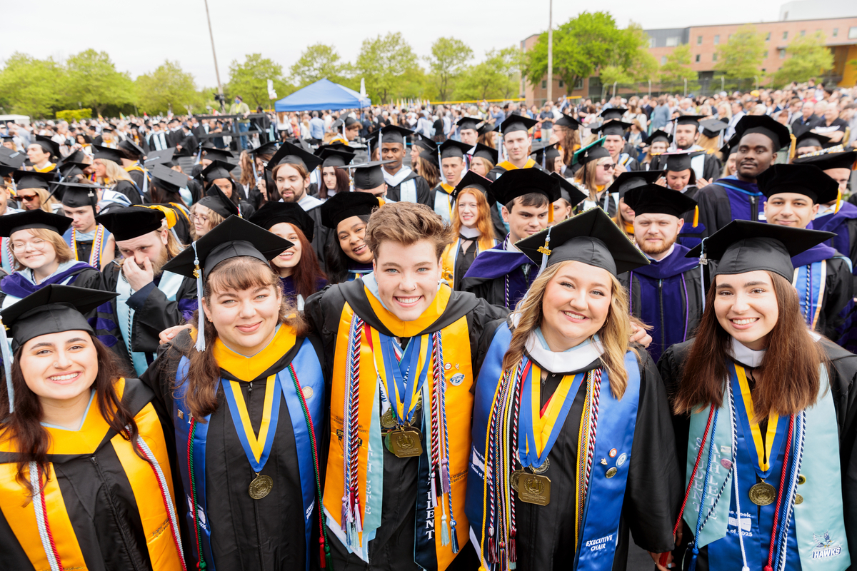A group of President's Core Values Medallion recipients celebrate at the 2025 Commencement ceremony.