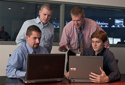 Professor and students working on a computer