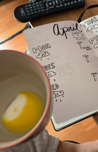 Water with lemon and open journal, with "April" written on the page.