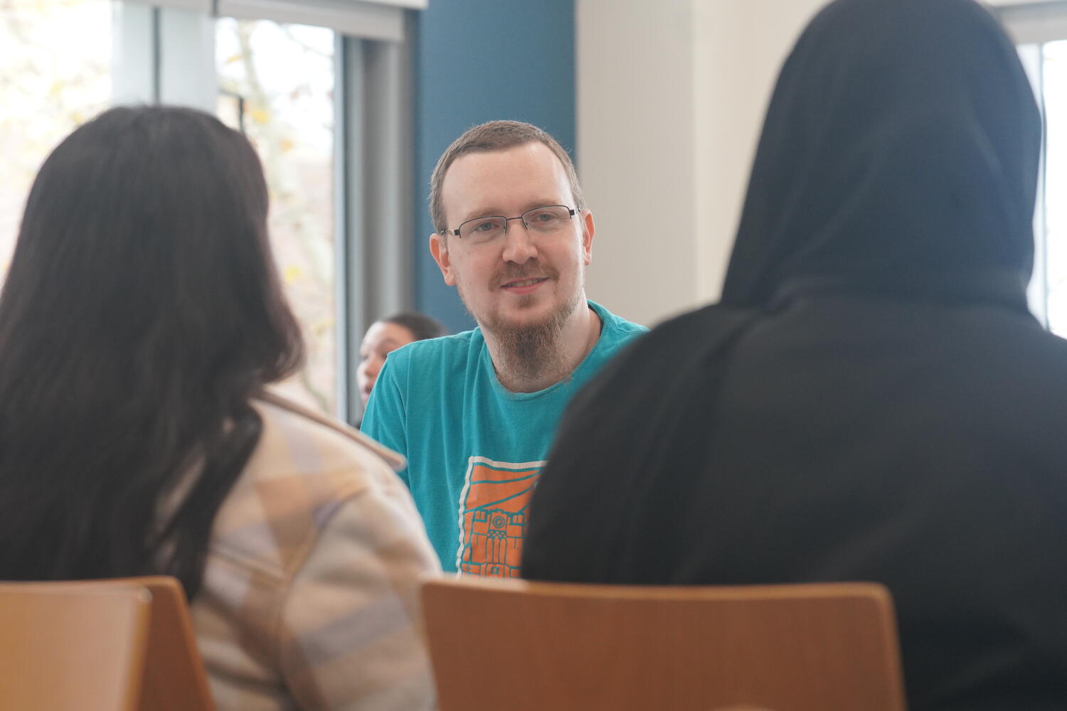 Professor Scott Benson speaks in depth with two students.