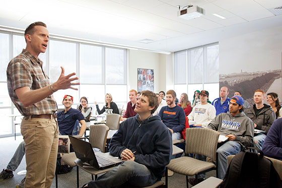 Professor at the front of a classroom.