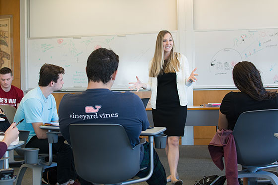 Professor conversing with students.