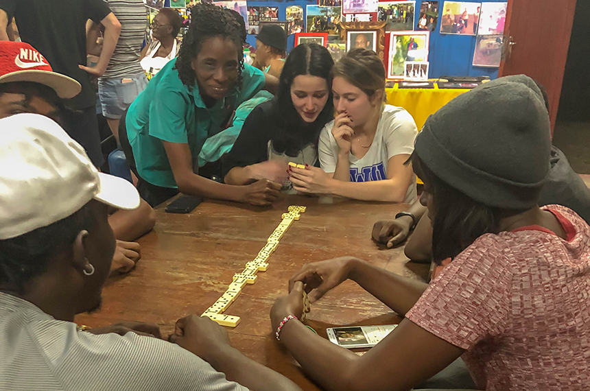 RWU student playing dominoes with Jamaican residents