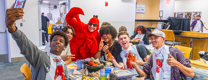 Students pose at steak and lobster dinner