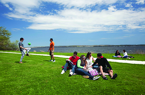 image of students sitting near the water in RWU's Bristol campus