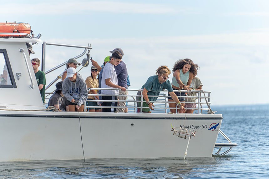 Students conduct experiments on a boat out on the bay