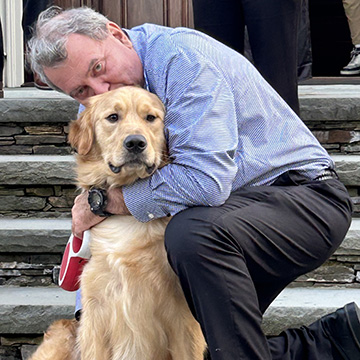 Ioannis Miaoulis kisses and hugs his golden retreiver