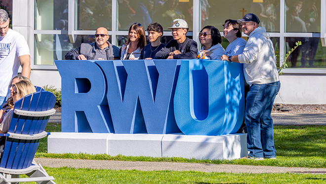 People pose with RWU logo during family weekend