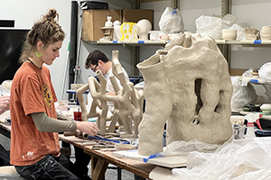 Student Marina Caspe works in the clay studio building a large sculpture