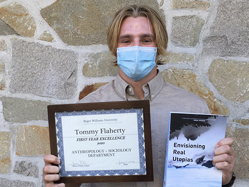 Tommy holds a certificate and book