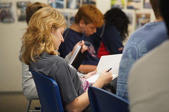 Student writing in notebook