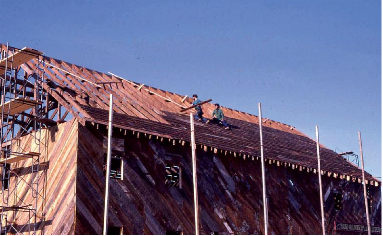 Students roofing the re-assembled barn