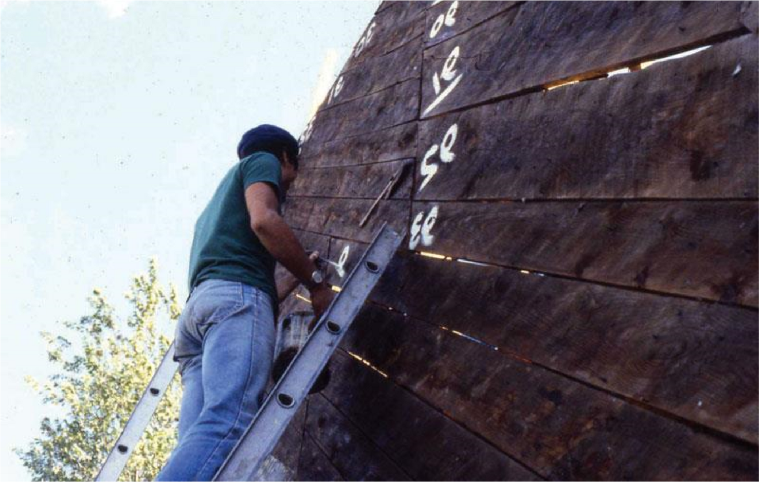 Student writing numbers on barn architectural elements