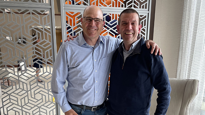 Dean Griffin stands with his college roommate