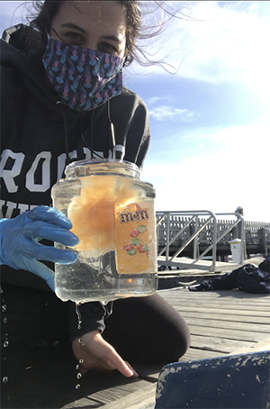 Malaika holds a jellyfish in a jar