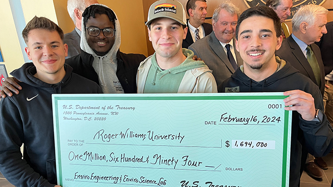 Four RWU students hold a check from Senator Jack Reed