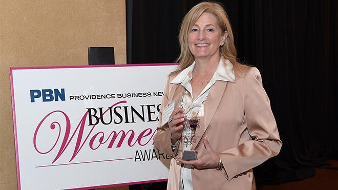 Laura Baldwin holds an award.