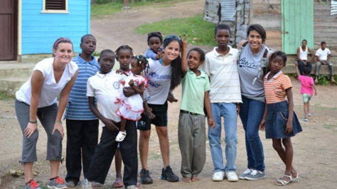 Students pose with children in a Haitian village