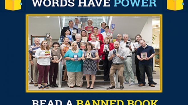 A group of faculty members hold up books.
