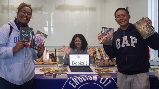 Students holding up books at Book Nook