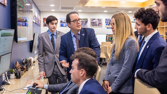 Students work with their professor in the Center for Advanced Financial Education