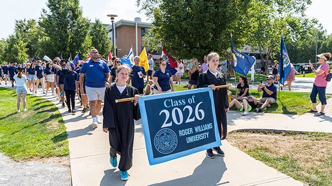 Students hold the Class of 2026 banner and lead the procession to Convocation.