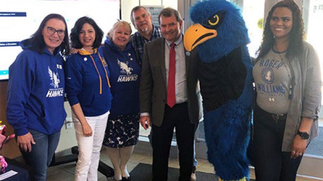 President Miaoulis poses with RWU's mascot and employees.
